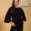 Woman with brown hair wearing black organic cotton wide sleeves blouse and black organic cotton long pants