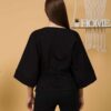 Woman with brown hair wearing black organic cotton wide sleeves blouse and black organic cotton long pants