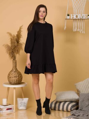 Woman with brown hair wearing black organic cotton dress with bouffant sleeves