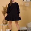 Woman with brown hair wearing black organic cotton dress with bouffant sleeves