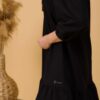 Woman with brown hair wearing black organic cotton dress with bouffant sleeves
