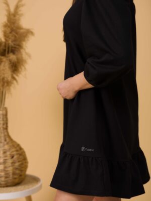 Woman with brown hair wearing black organic cotton dress with bouffant sleeves