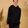 Woman with brown hair wearing black long-sleeved sweatshirt with a hood and ruffles, and black organic cotton long pants