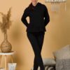 Woman with brown hair wearing black long-sleeved sweatshirt with a hood and ruffles, and black organic cotton long pants