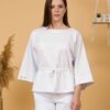 Woman with brown hair wearing white organic cotton wide sleeves blouse and white organic cotton wide long pants