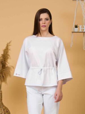 Woman with brown hair wearing white organic cotton wide sleeves blouse and white organic cotton wide long pants