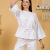 Woman with brown hair wearing white organic cotton wide sleeves blouse and white organic cotton wide long pants