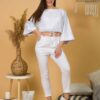 Woman with brown hair wearing white organic cotton wide sleeves blouse and white organic cotton wide long pants