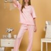 Woman with blond hair wearing pink organic cotton pajama set of short sleeve blouse and long pants