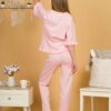 Woman with blond hair wearing pink organic cotton pajama set of short sleeve blouse and long pants