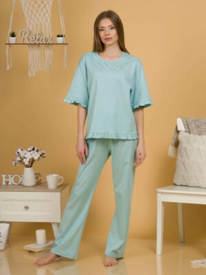 Woman with blond hair wearing turquoise organic cotton pajama set of short sleeve blouse and long pants