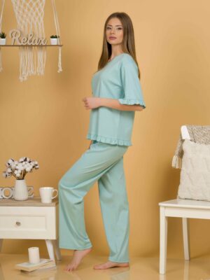 Woman with blond hair wearing turquoise organic cotton pajama set of short sleeve blouse and long pants