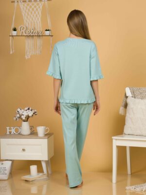 Woman with blond hair wearing turquoise organic cotton pajama set of short sleeve blouse and long pants