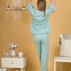 Woman with blond hair wearing turquoise organic cotton pajama set of short sleeve blouse and long pants