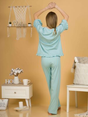Woman with blond hair wearing turquoise organic cotton pajama set of short sleeve blouse and long pants