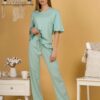 Woman with blond hair wearing turquoise organic cotton pajama set of short sleeve blouse and long pants