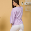 Woman with brown hair wearing violet organic cotton wide sleeves blouse and violet organic cotton long pants