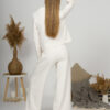 Woman with blond hair wearing organic cotton white blouse with semi-polo neck and white wide long pants