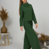 Woman with blond hair wearing organic cotton dark green color blouse with semi-polo neck and white dark green color long pants