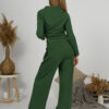 Woman with blond hair wearing organic cotton dark green color blouse with semi-polo neck and white dark green color long pants