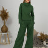Woman with blond hair wearing organic cotton dark green color blouse with semi-polo neck and white dark green color long pants