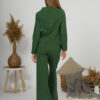 Woman with blond hair wearing organic cotton dark green color blouse with semi-polo neck and white dark green color long pants