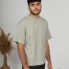 a young man with black hair wearing organic cotton gray t-shirt and black trousers