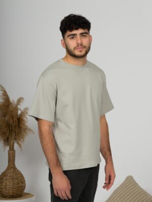a young man with black hair wearing organic cotton gray t-shirt and black trousers