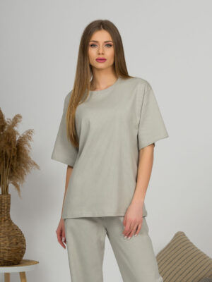 A young woman with blond hair wearing organic cotton gray t-shirt and gray straight leg trousers