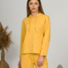 A young woman with blond hair wearing organic cotton hooded blouse and straight leg trousers in yellow color
