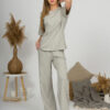 A young woman with blond hair wearing organic cotton t-shirt and straight leg trousers in gray color