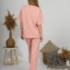 A young woman with blond hair wearing organic cotton t-shirt and straight leg trousers in pink color