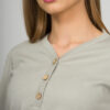 A young woman with blond hair wearing organic cotton blouse with coconut buttons