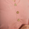 A young woman with blond hair wearing organic cotton blouse with coconut buttons