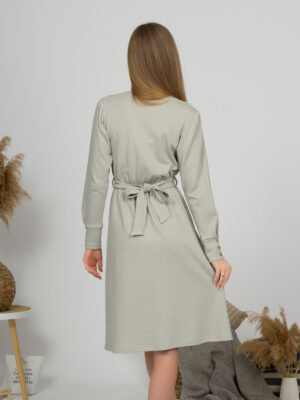 Woman with blond hair wearing organic cotton gray color long sleeves dress with coconut buttons