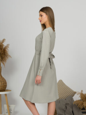 Woman with blond hair wearing organic cotton gray color long sleeves dress with coconut buttons