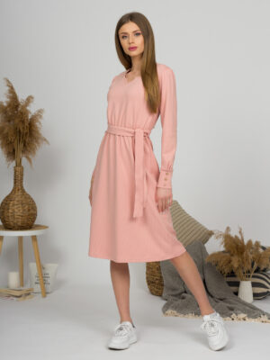 Woman with blond hair wearing organic cotton pink color long sleeves dress with coconut buttons