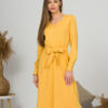 Woman with blond hair wearing organic cotton yellow color long sleeves dress with coconut buttons