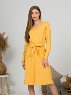 Woman with blond hair wearing organic cotton yellow color long sleeves dress with coconut buttons