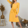 Woman with blond hair wearing organic cotton yellow color long sleeves dress with coconut buttons