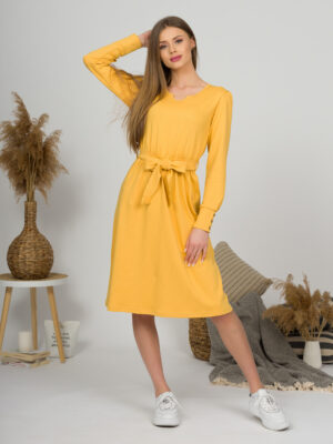 Woman with blond hair wearing organic cotton yellow color long sleeves dress with coconut buttons