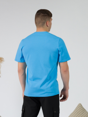Young man wearing organic cotton blue color t-shirt with colored print and black trousers