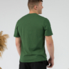 Young man wearing organic cotton green color t-shirt with colored print and black trousers
