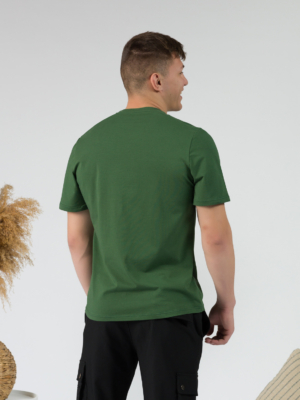 Young man wearing organic cotton green color t-shirt with colored print and black trousers