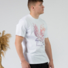 Young man wearing organic cotton white color t-shirt with colored print and black trousers