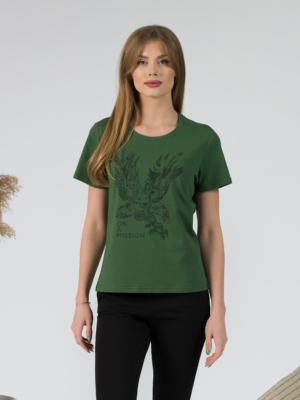 A young woman with blond hair wearing organic cotton green color t-shirt with colored print and black trousers