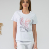 A young woman with blond hair wearing organic cotton white color t-shirt with colored print and white trousers