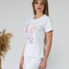 A young woman with blond hair wearing organic cotton white color t-shirt with print and white trousers