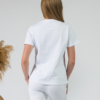 A young woman with blond hair wearing organic cotton white color t-shirt with print and white trousers