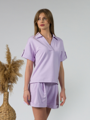 Young woman with blond hair wearing organic cotton violet blouse t-shirt and organic cotton violet shorts